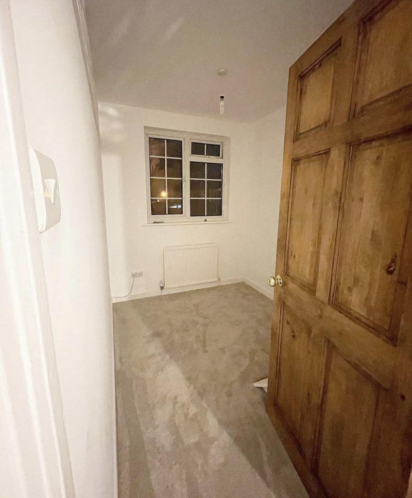small bedroom, freshly painted with a white paint and a beige carpet installed. Project by The Big Conversion Company.